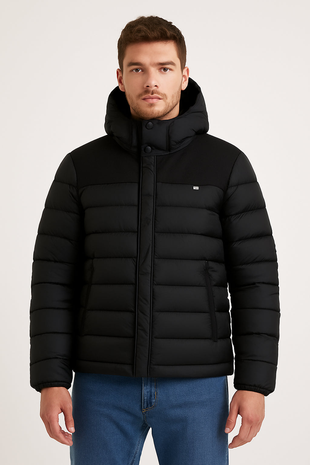 Giubbino Invernale Comfort, giacca imbottita nera con cappuccio e tasche, perfetta per l'inverno.